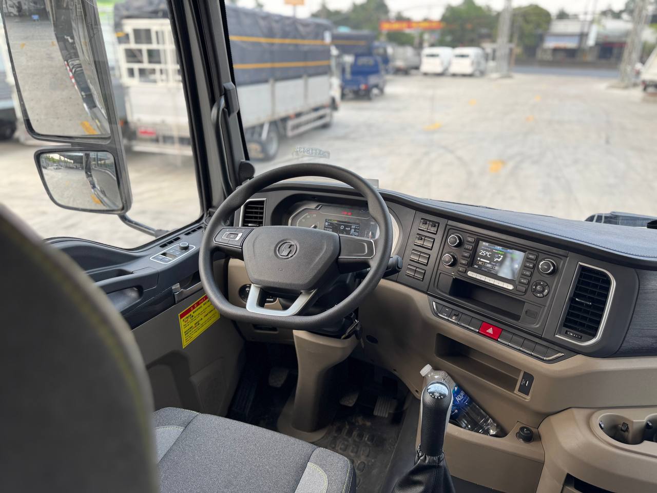 Ảnh chụp nội thất cabin xe ben Shacman H3000S, tập trung vào vô lăng và bảng điều khiển trung tâm