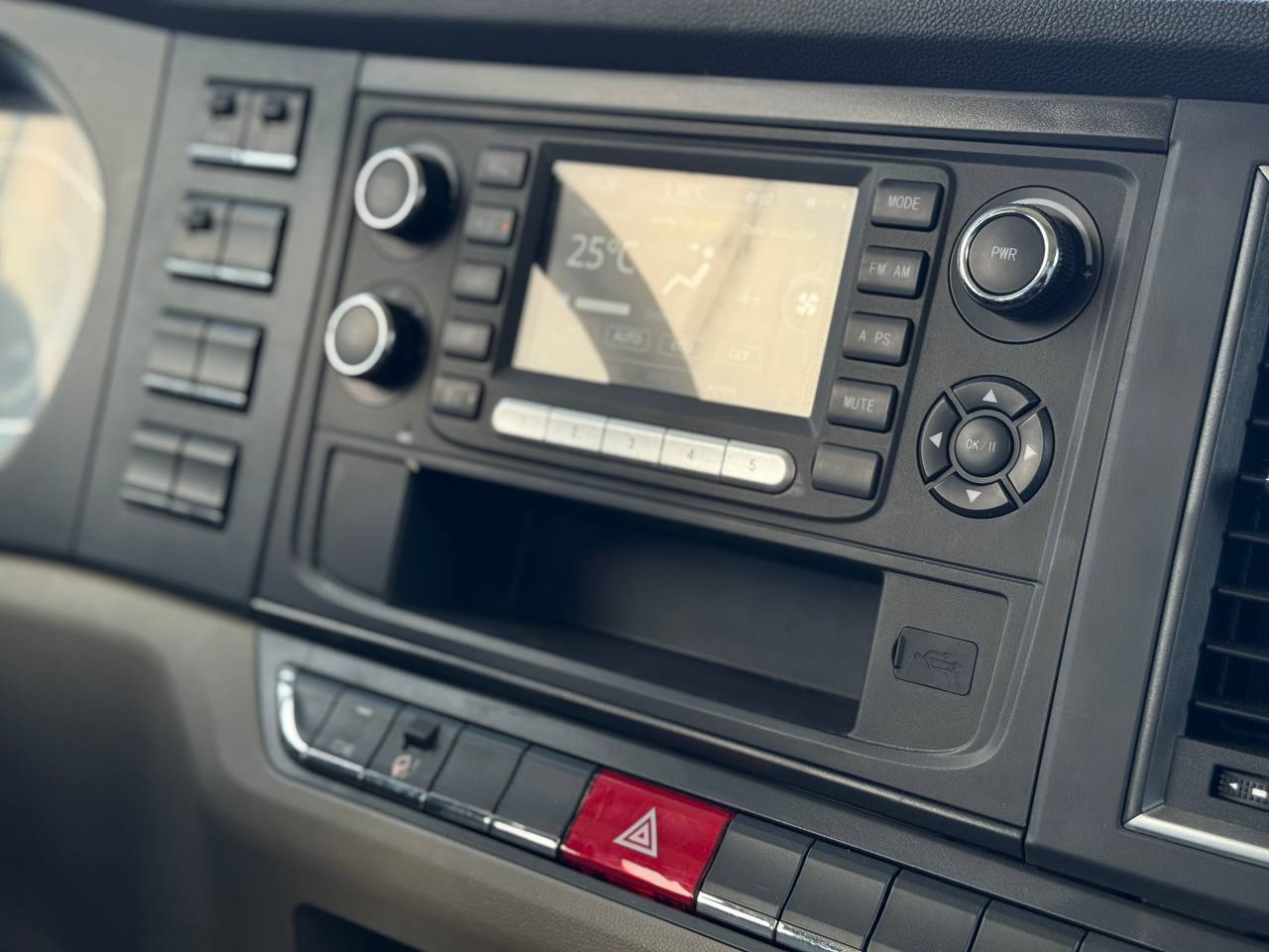 Ảnh chụp cận cảnh bảng điều khiển trung tâm của xe ben Shacman H3000S, hiển thị hệ thống giải trí với các nút chức năng