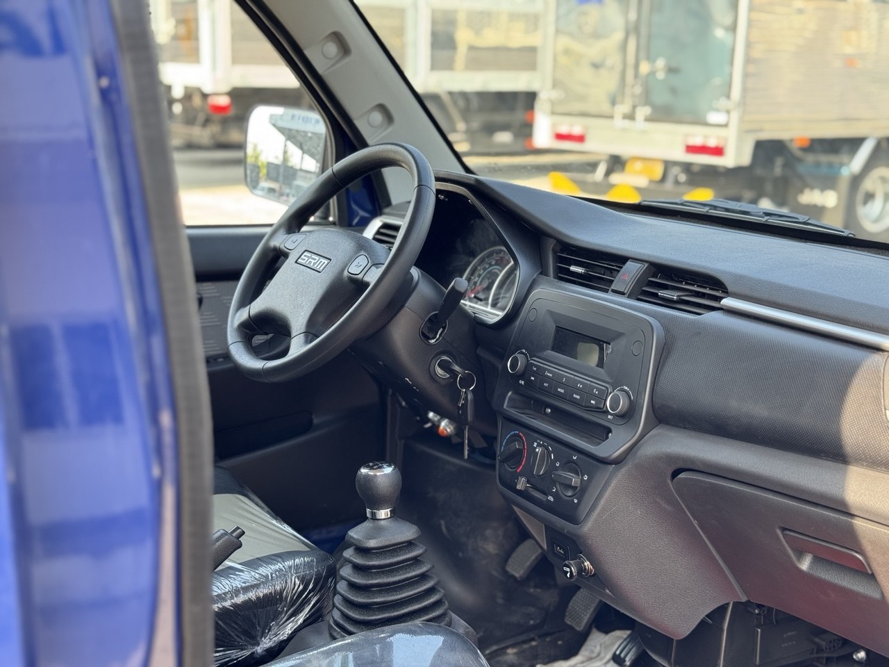 Ảnh chụp nội thất cabin xe SRM K990 với vô lăng, bảng điều khiển và cần số