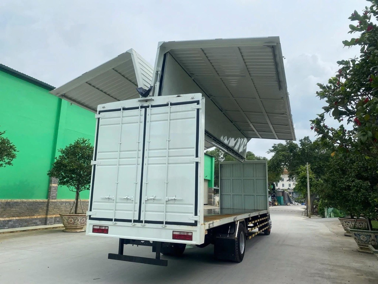 Xe tải JAC A5 thùng kín cánh dơi đang mở, góc sau bên phải