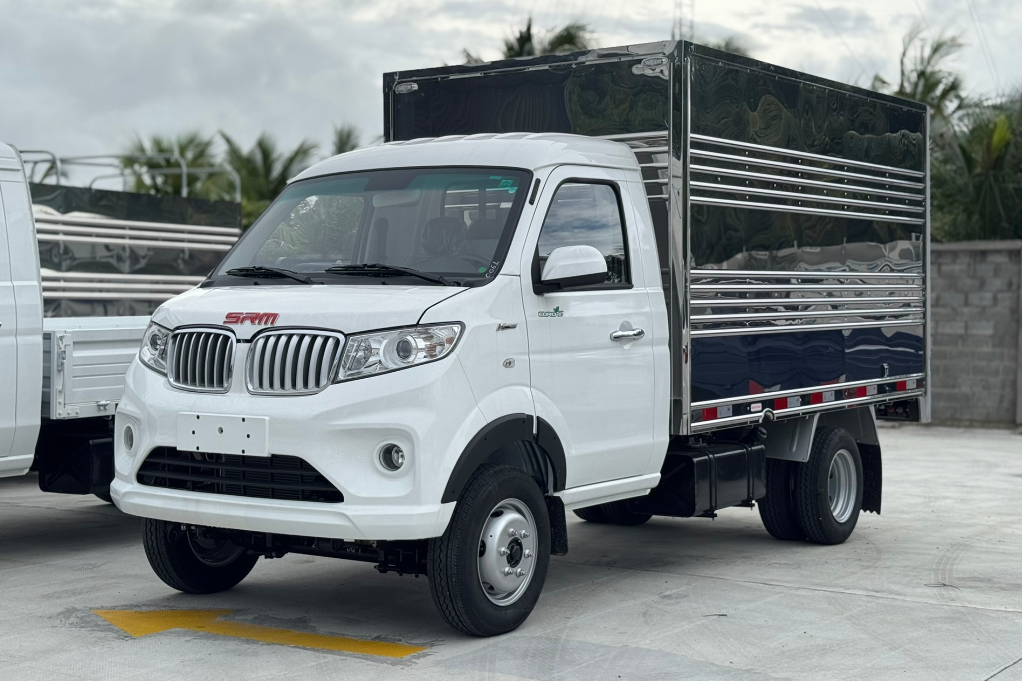 Bối cảnh tại một trạm xăng PVOIL, một người đàn ông mặc áo sơ mi trắng đang thanh toán cho nhân viên PVOIL mặc đồng phục màu xanh. Một chiếc ô tô màu trắng đang được đổ xăng E10 RON95-V. Trụ bơm xăng hiển thị rõ 