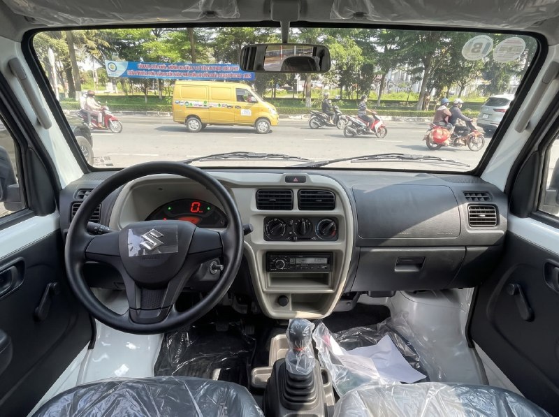 Ảnh cận cảnh hệ thống treo sau (lò xo cuộn và giảm chấn thủy lực) phía trên lốp xe Suzuki Eeco.